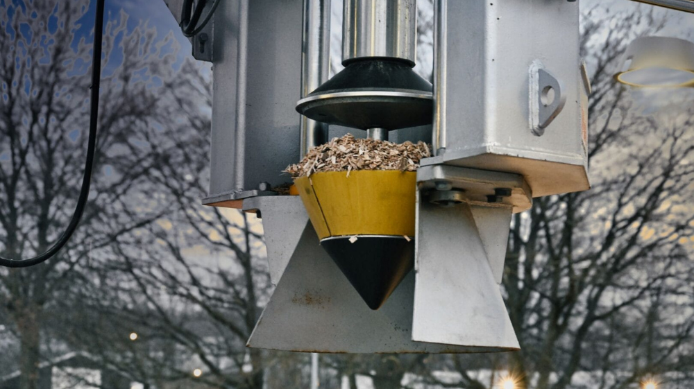 Automated sampling head collecting a representative sample at a random depth point within the truck load